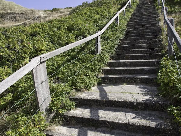 Chemin en escaliers qui monte dans les dunes